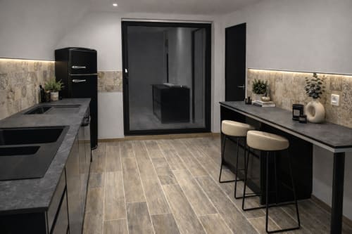 Cuisine moderne noir et beige du gîte Le Hangar 7 à Guilvinec, avec îlot central et design contemporain