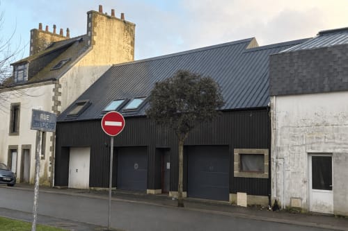 Immeuble en tôle ondulée noire « Le Hangar 7 » à Guilvinec, Bretagne, avec entrée privée et panneau d'interdiction d'accès