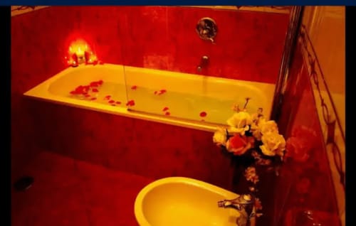 Lussuoso bagno rosso e oro presso B&B Alla Basilica con vasca spa riempita di petali di rosa a San Giovanni
