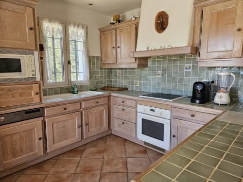 Cuisine lumineuse de la Villa Les Cyprès au Domaine de L'Échappée Belle, Entrecasteaux, avec meubles en bois et carrelage vert