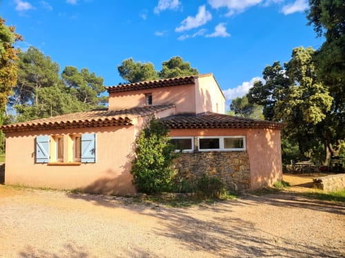 Rustic terracotta cottage at Domaine de L'Échappée Belle in Entrecasteaux with stone accents and lush green surroundings