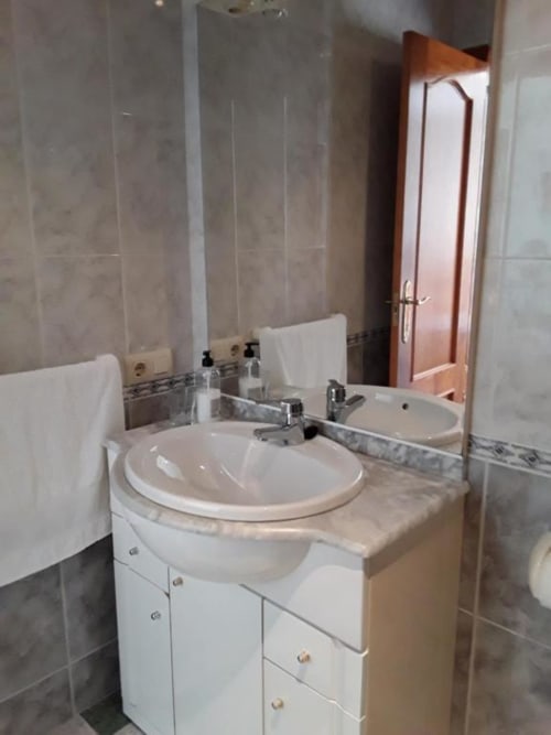 Modern bathroom with round sink, white vanity, and large mirror at Hostal San Andres in Carboneras