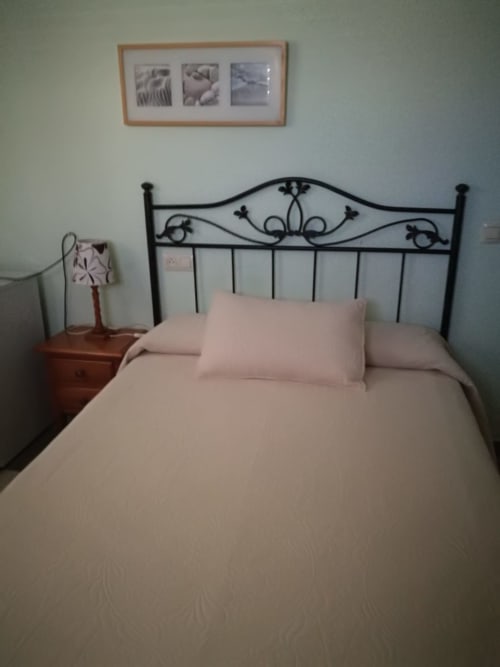 Double suite bedroom at Hostal San Andres in Carboneras with wrought iron bed frame and pink bedding