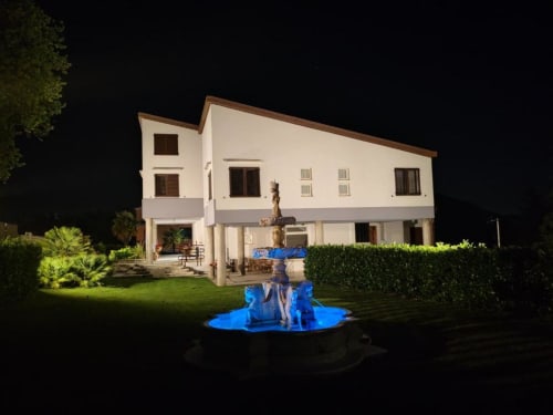 Villa Andreina di notte con fontana illuminata, affascinante facciata bianca e giardini curati a Sarnano