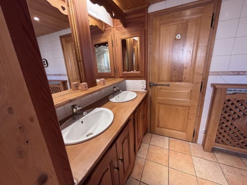Luxury bathroom in Chalet Marie Claire with double sinks, wooden cabinetry, and mirror at Chez Francine, Notre Dame de