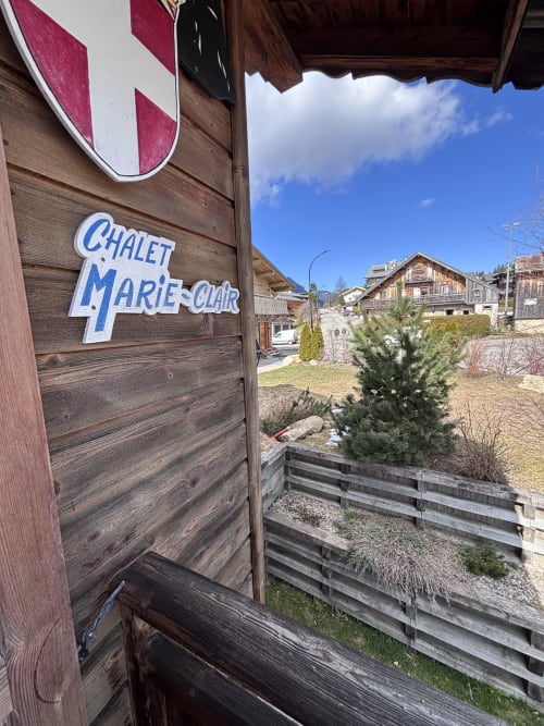 Chalet Marie-Claire entrance sign with wooden door, mountain village view, Notre Dame de Bellecombe