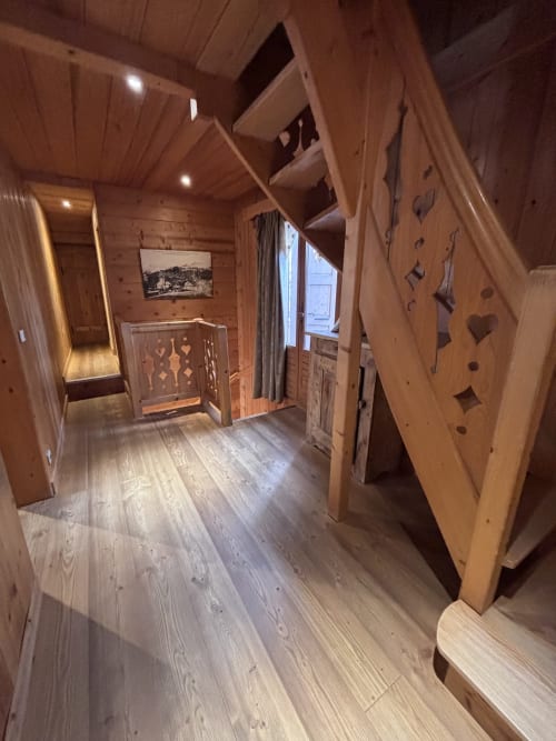 Wooden interior hallway of Chalet Marie Claire at Chez Francine, Notre Dame de Bellecombe, with decorative doors and warm