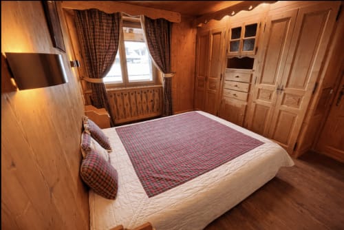 Chambre chaleureuse en bois avec lit queen-size, literie à carreaux, télévision écran plat et armoire en bois chez Francine, Notre Dame de Bellecombe