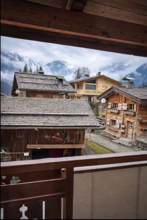 Wooden balcony view of traditional Alpine chalets with snow-capped mountains in background at Chez Francine, Notre Dame de