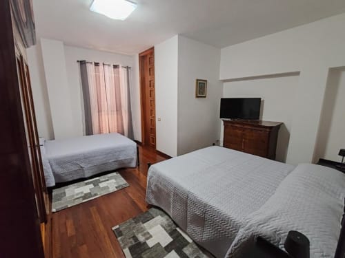 Villa Andreina Triple Comfort Room in Sarnano with two beds, wooden furniture, and mountain views
