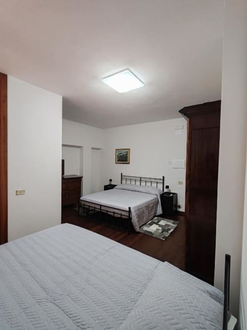 Triple Comfort room at Villa Andreina B&B in Sarnano with two beds, dark wood furniture, and mountain view
