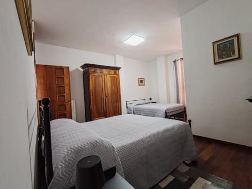 Triple Comfort bedroom at Villa Andreina B&B in Sarnano with two beds, wooden wardrobes, and mountain views