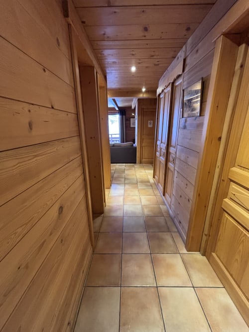 Wooden corridor with tile flooring in Chez Marion apartment, Notre Dame de Bellecombe, leading to living areas