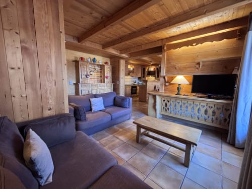 Spacious wooden chalet living room with seating, TV, and mountain views at Chez Marion, Notre Dame de Bellecombe