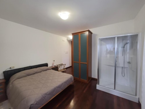 Spacious double bedroom at Villa Andreina in Sarnano with en-suite shower, wardrobe, and modern amenities