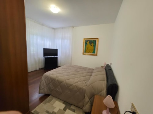 Double bedroom at Villa Andreina B&B in Sarnano with TV, sheer curtains, and framed artwork