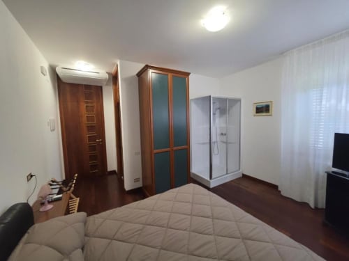 Spacious double room at Villa Andreina in Sarnano with en-suite shower, TV, and garden views