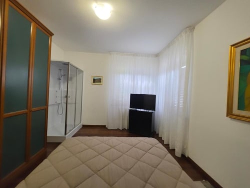 Double room at Villa Andreina B&B in Sarnano with bed, ensuite shower, TV, and garden view