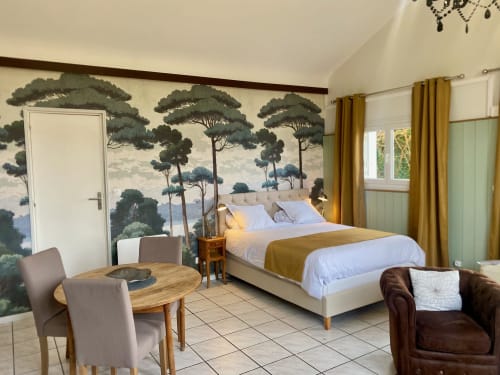 Schlafzimmer mit Meerblick-Wandmalerei, Doppelbett, Esstisch und goldfarbenen Vorhängen im Destination Etretat Cottage in der Normandie, Frankreich