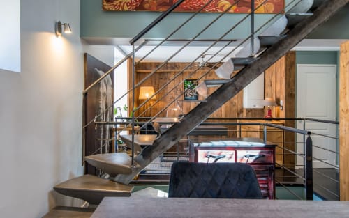 Escalier duplex moderne dans un appartement à Millau avec murs en bois, rampes métalliques et design contemporain surplombant le séjour