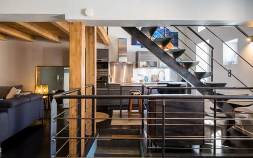 Duplex moderne à Millau avec séjour ouvert, cuisine intégrée et escalier métallique noir avec rangements
