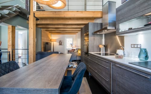 Cuisine et salle à manger contemporaines à Millau avec poutres en bois, mobilier foncé et vue sur la ville