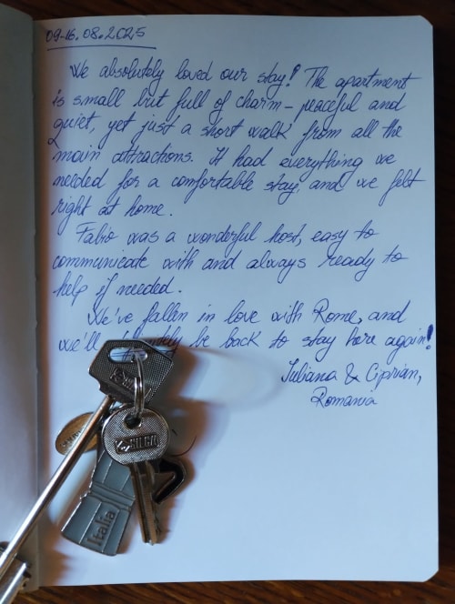 Recensione di ospite manuscritta che elogia l'appartamento di Roma con le chiavi esposte sulla pagina del taccuino