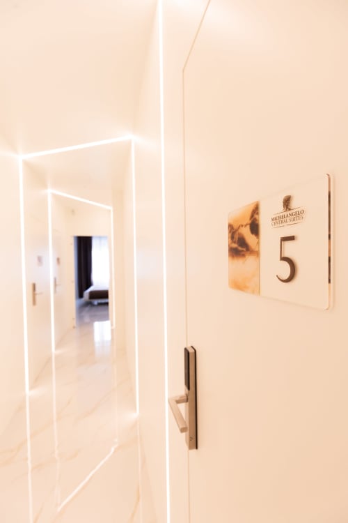 Ingresso della suite dell'Hotel Michelangelo Central Suites a Firenze, porta della camera 5 con maniglia moderna e cornice illuminata