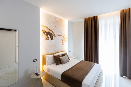 Camera matrimoniale deluxe al Michelangelo Central Suites di Firenze con arredamento moderno, opere d'arte e illuminazione dorata