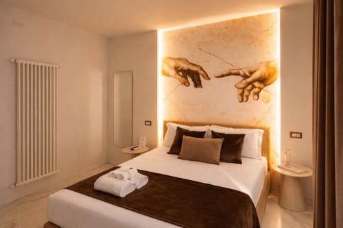 Camera matrimoniale deluxe presso Michelangelo Central Suites a Firenze, con opera d'arte mani del Rinascimento illuminate sopra il letto