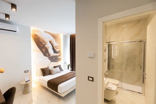Suite Deluxe Michelangelo Central a Firenze con camera moderna, bagno in marmo e design contemporaneo