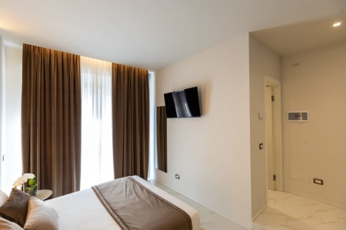 Suite Deluxe Michelangelo Central a Firenze con letto moderno, TV a parete e finestre dal pavimento al soffitto