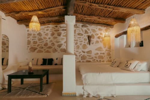 Suite Beldi rústica en el Riad Eucalyptus con muros de piedra, vigas de madera, arañas de bronce y decoración marroquí tradicional