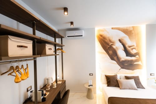 Camera Deluxe delle Michelangelo Central Suites a Firenze con scaffalature moderne, decorazioni murali artistiche e letto contemporaneo