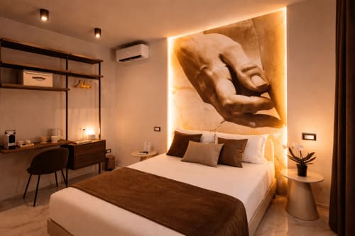 Lussuosa suite deluxe al Michelangelo Central Suites di Firenze con arte scultorea, illuminazione calda e servizi moderni.