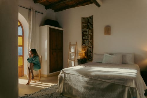 Bright ethnic-style bedroom at Riad Eucalyptus in Essaouira with colorful stained glass window and traditional décor