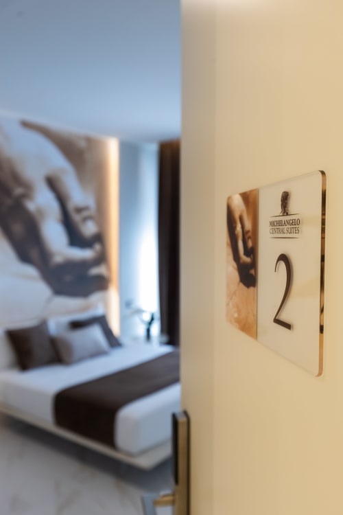 Targhetta della Sala 2 presso Michelangelo Central Suites a Firenze, con camera da letto Deluxe visibile all'interno