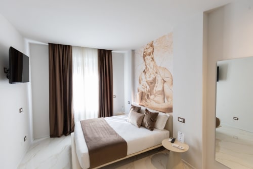 Camera Superior con letto queen delle Michelangelo Central Suites Firenze: arredamento moderno, opere d'arte, tendaggi marroni e TV