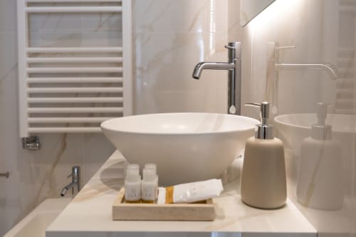 Moderno bagno con lavabo a coppa bianco e rubinetto cromato alle Michelangelo Central Suites di Firenze