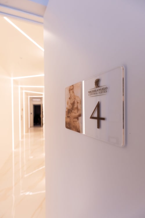 Insegna Stanza 4 presso Michelangelo Central Suites a Firenze, corridoio moderno con porta illuminata al neon