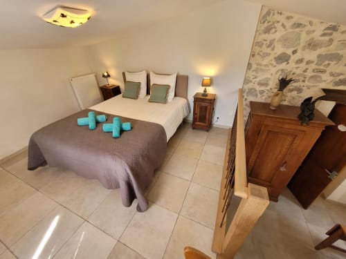 Spacieuse chambre du Gîte des Anges au Domaine de la Méouge avec deux lits, papier peint vue montagne et mobilier rustique