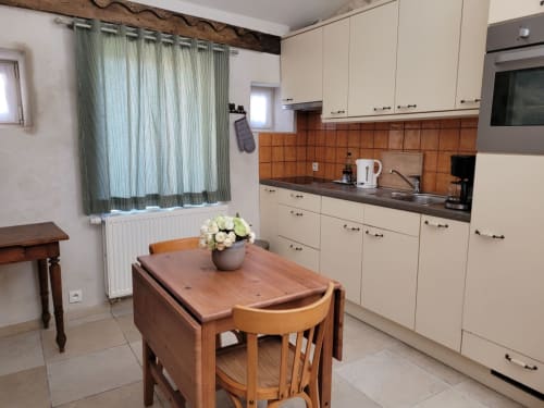 Cuisine et salle à manger du gîte des Anges au Domaine de la Méouge, avec mobilier crème et dosseret en carrelage terre cuite