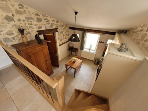 Intérieur cosy du gîte du Domaine de la Méouge : mobilier en bois, papier peint à motifs, séjour ouvert