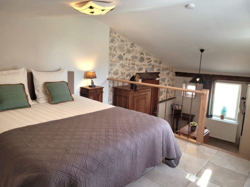Chambre spacieuse du gîte des Anges au Domaine de la Méouge, avec lit queen-size, oreillers verts et mobilier en bois