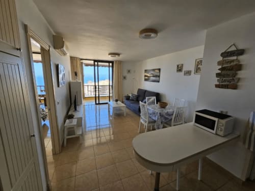 Helles Strandapartment auf Teneriffa mit offener Küche, Essbereich, Wohnzimmer, Meerblick-Balkon und moderner Ausstattung