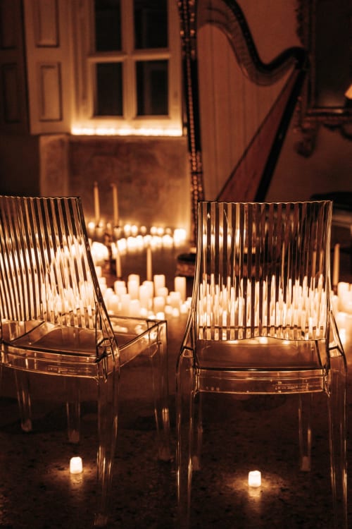 Due sedie trasparenti affacciate sul cortile illuminato a candela del Palazzo Fauzone Relais & Spa a Mondovì, Italia