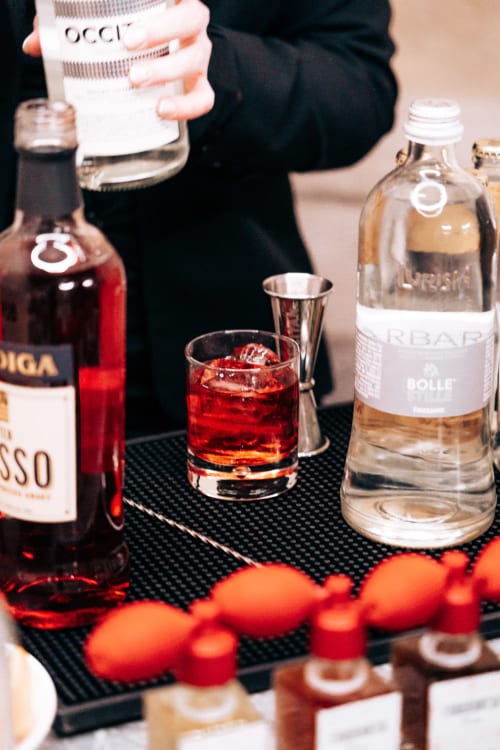 Elegante bar dei cocktail a Palazzo Fauzone con bevanda rossa, bottiglie e ornamenti festivi