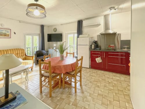 Studio à Digne-les-Bains avec cuisine rouge, table à manger, canapé et espace de vie ouvert