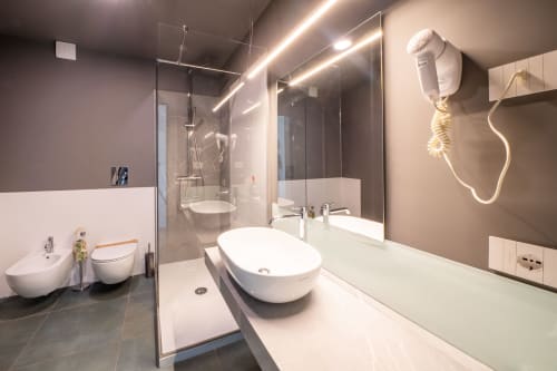 Bagno moderno della Junior Suite dell'Hotel Belvedere Resort con lavabo bianco, doccia in vetro e scaldasalviette
