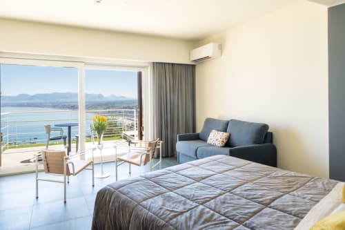 Junior Suite Vista Mare dell'Hotel Belvedere Resort con vista sul mare, balcone affacciato su Castellammare del Golfo, divano blu e